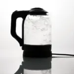Sleek electric glass kettle boiling water on reflective surface