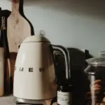White electric kettle on kitchen table with cozy setting